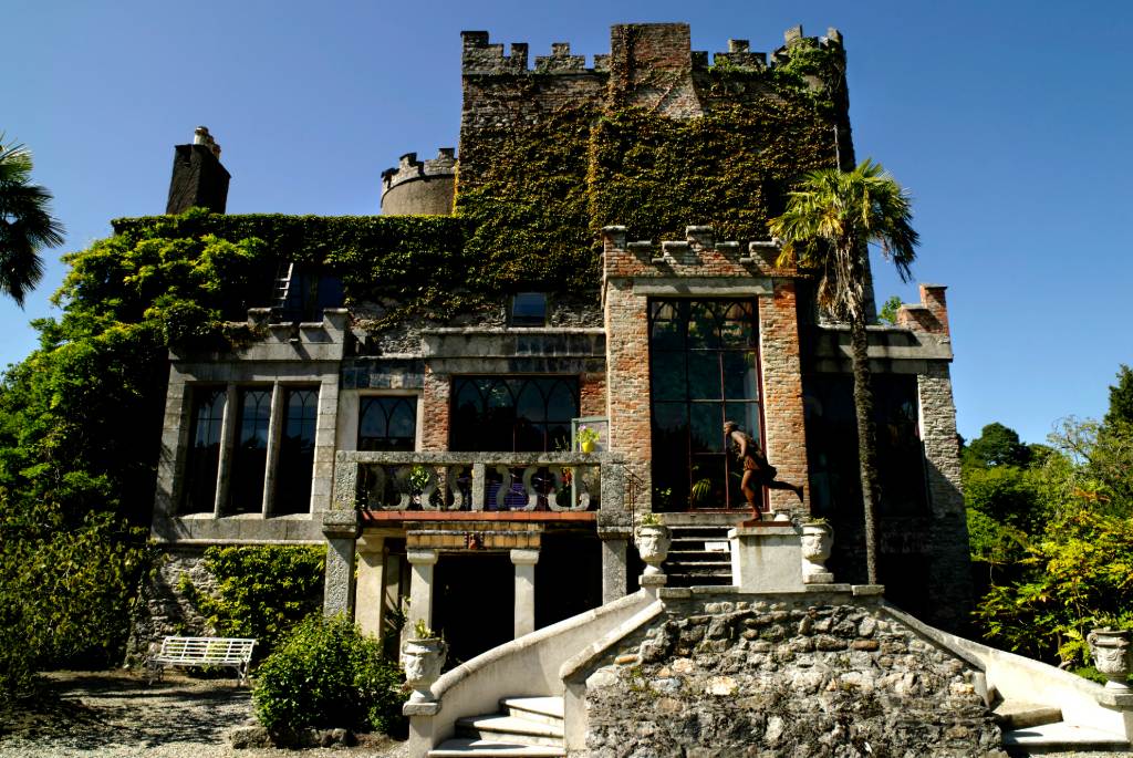Exterior of ivy-covered Huntington Castle in County Carlow with stone steps and lush greenery.