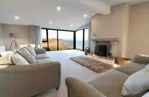 Contemporary living room with large corner windows and sea views over Castlerock beach in County Londonderry.