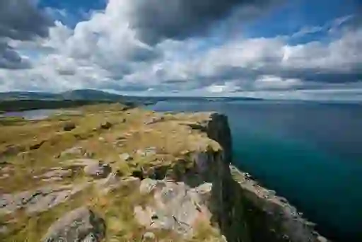 Sweeping view from Fair Head in County Antrim, with rocky plateau and distant sea beneath dramatic skies.