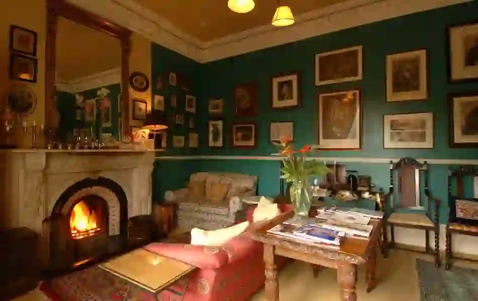 Traditional parlour with roaring fireplace and vintage decor at The Mustard Seed at Echo Lodge, County Limerick.