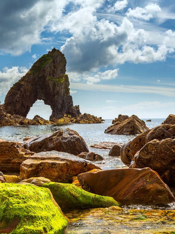 Jagged sea arch and rocky stacks rise from the Atlantic at Fanad Head, Donegal.