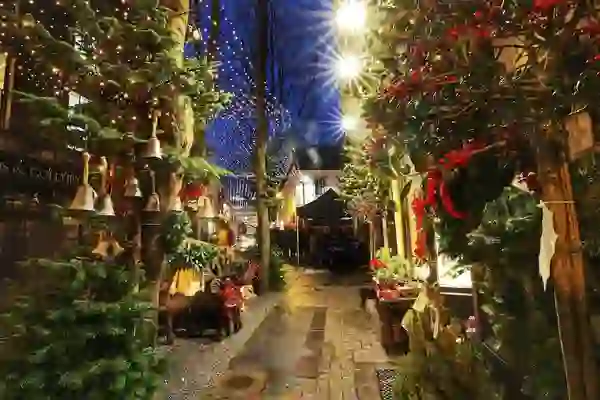 Festive alley in Galway decorated with Christmas wreaths, lights, and market stalls.