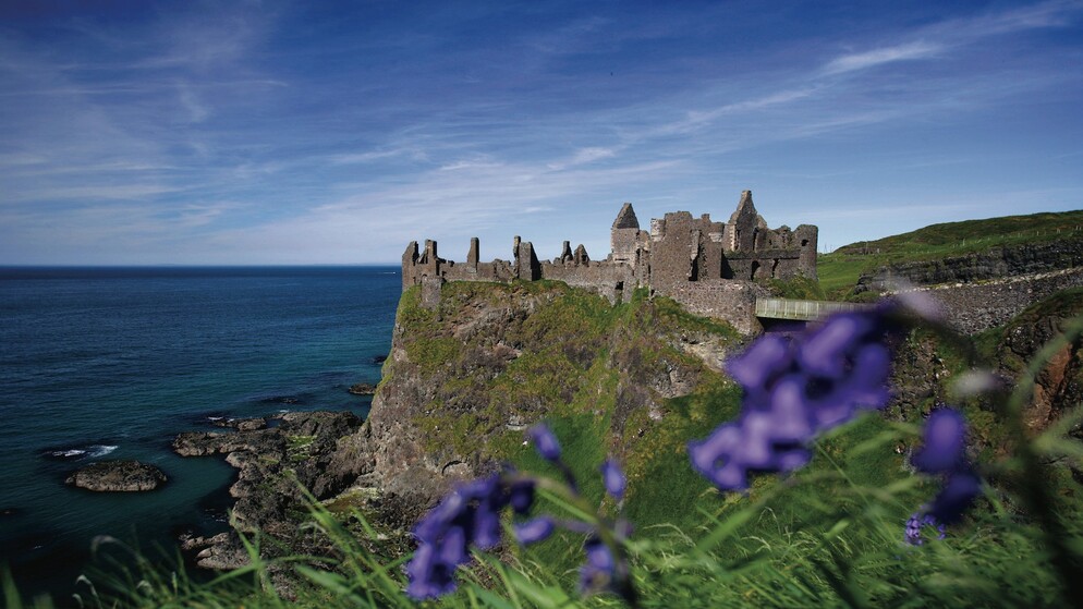 Ruins of Dunluce Castle perched on cliffs above the Atlantic Ocean in County Antrim, Northern Ireland.