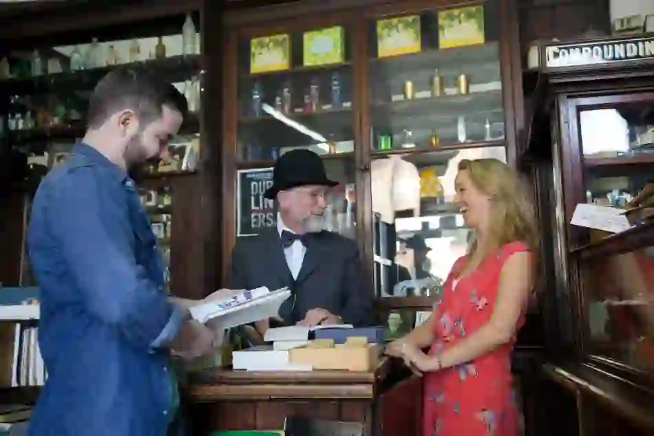 Visitors chatting with guide in period costume at Sweny’s Pharmacy, Dublin.