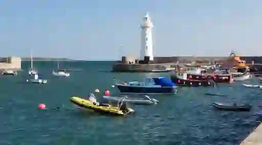 Donaghadee Lighthouse stands above a harbour with fishing boats and yachts in County Down.
