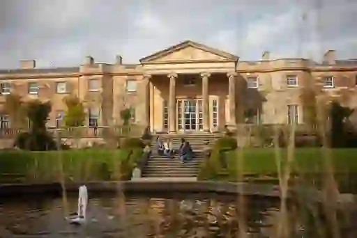 Hillsborough Castle and Gardens in County Down, with visitors sitting on the steps by the fountain.