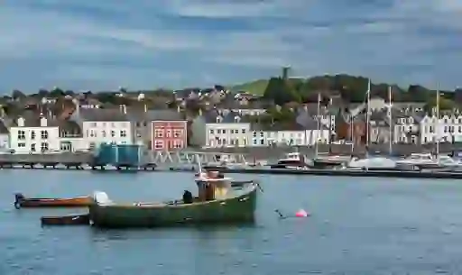 Harbourfront of Portaferry, County Down, with colourful houses and fishing boats in the water.