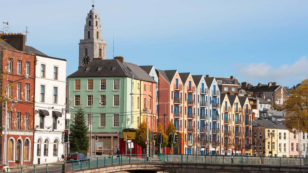 Colourful houses along a street in Cork city with Shandon Tower rising in the background.