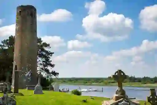 Ancient round tower and Celtic crosses at Clonmacnoise monastery overlooking the River Shannon.