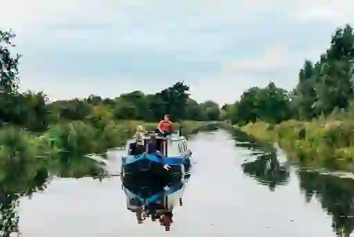 Family standing on a barge cruising through the Grand Canal near Sallins, County Kildare.