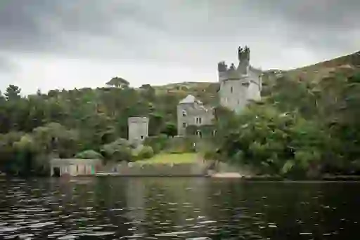 Glenveagh Castle on the shores of Lough Veagh surrounded by forest in Glenveagh National Park.