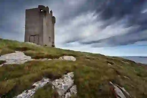 Napoleonic signal tower standing on a grassy hilltop overlooking the Atlantic coastline in Donegal.