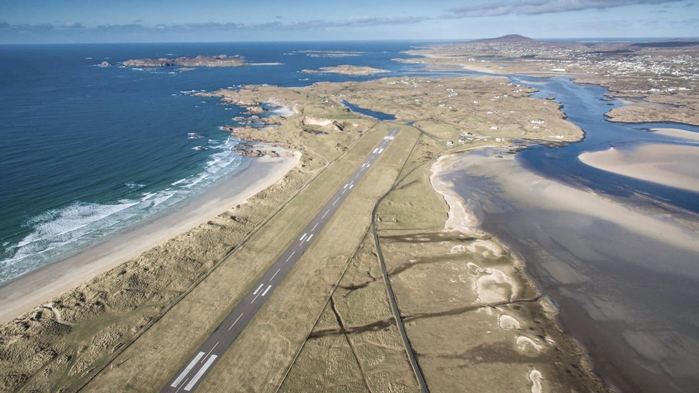 Aerial view of Donegal Airport's coastal runway surrounded by beaches, dunes, and tidal inlets in County Donegal, Ireland.