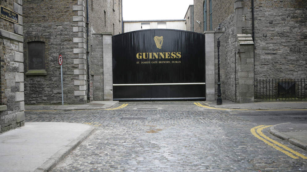 Black gates with gold Guinness logo at St James’s Gate Brewery in Dublin, Ireland.