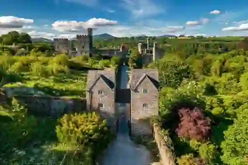 Aerial view of Lismore Castle surrounded by trees and walled gardens.