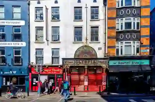 The historic Olympia Theatre in Dublin city centre, with its ornate façade beside restaurants and shops.