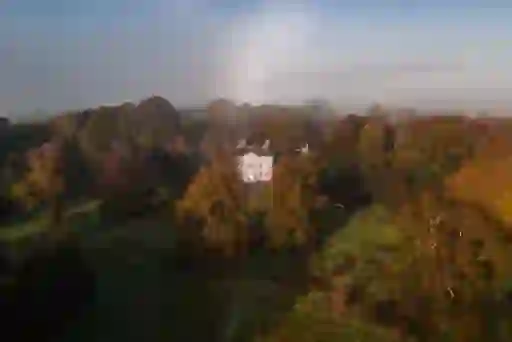 Roundwood House surrounded by tall autumn trees under misty morning light in County Laois.