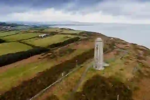 Wicklow Head Lighthouse overlooking coastal farmland and sea cliffs in County Wicklow.