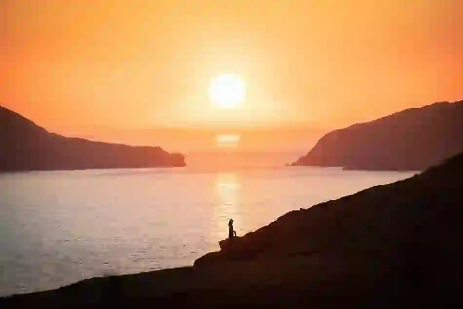 View of a sheep grazing with Skellig Michael rising from the Atlantic in the distance, on the Skellig Ring scenic route.