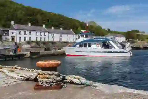 Rathlin Island ferry arriving at the harbour in County Antrim, with white cottages along the shore.