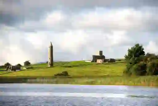 Round tower and monastery ruins on Devenish Island, Lough Erne, County Fermanagh, seen from the water.