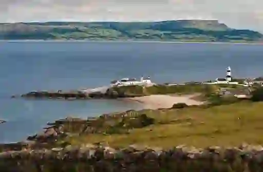 View of Stroove Lighthouse near Greencastle, County Donegal, with beach and cliffs across Lough Foyle.