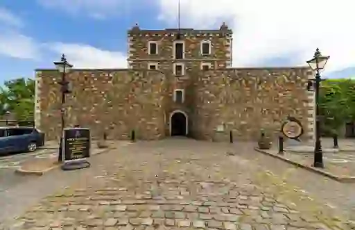 Stone facade of Wicklow Gaol in County Wicklow, framed by vintage lampposts and cobblestone courtyard.