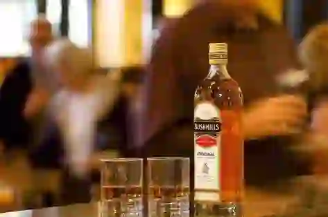 Bottle of Bushmills whiskey with glasses at Bushmills Distillery, County Antrim.