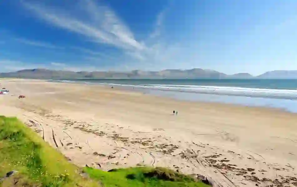 Wide sandy Inch Beach on the Dingle Peninsula, County Kerry, with mountains in the distance.