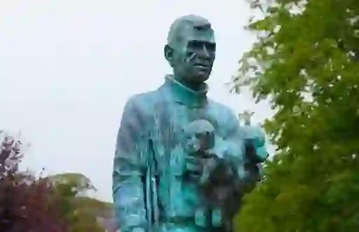 Bronze statue of Antarctic explorer Tom Crean holding puppies in Annascaul, County Kerry.