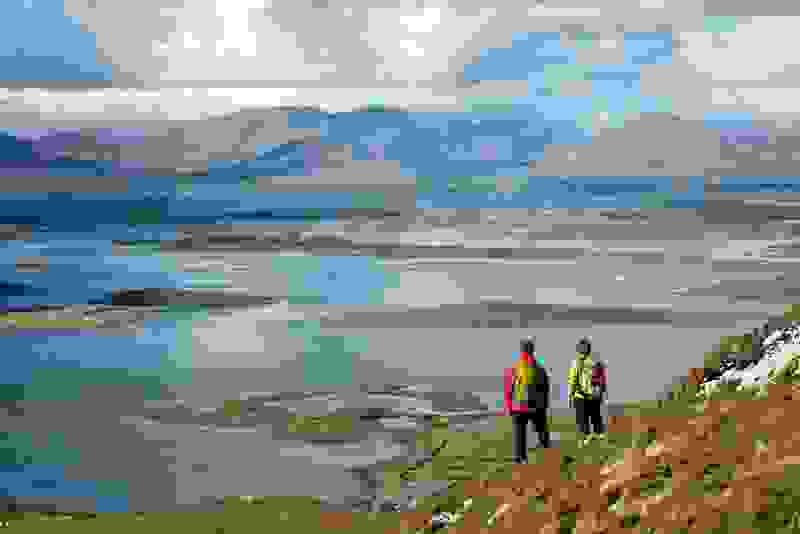 Hikers overlooking Clew Bay’s scattered islands with Croagh Patrick rising in the distance, County Mayo.