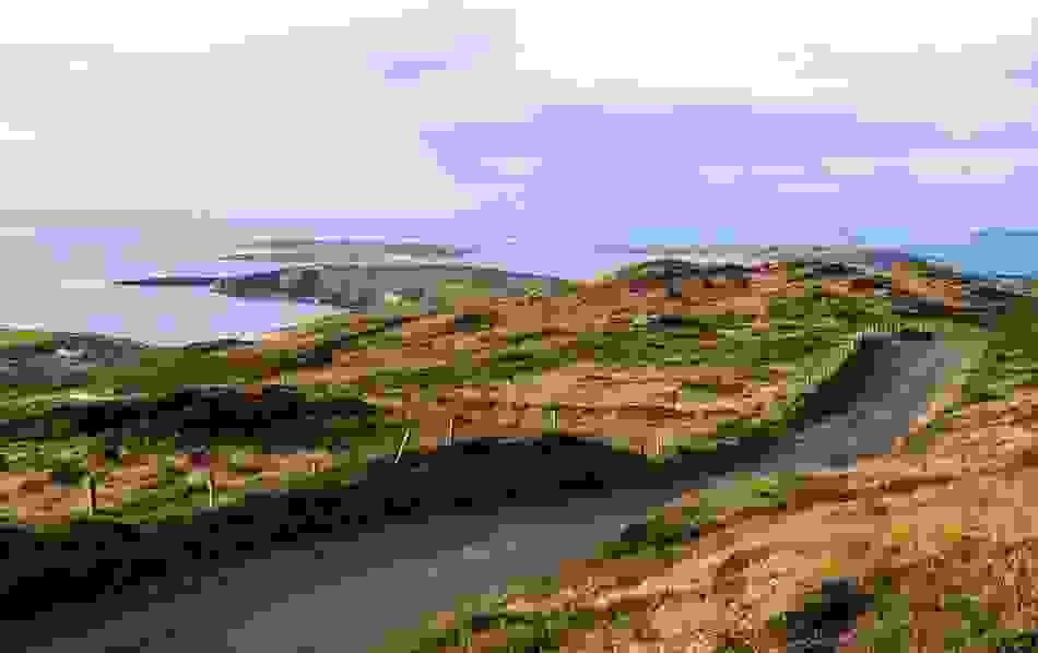 Coastal view from Sky Road in Clifden, where a narrow tarmac lane winds through rugged hills toward the Atlantic islands.