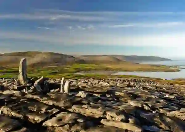 Limestone flagstones and standing stones overlook Galway Bay from Abbey Hill in County Clare.
