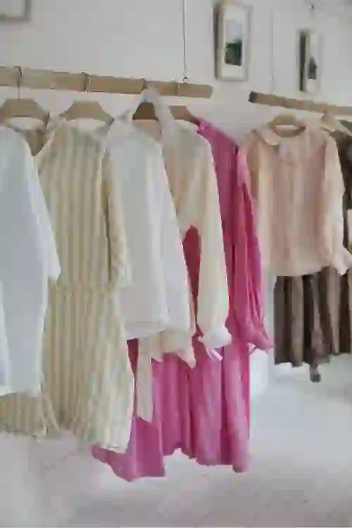 Pastel and striped linen clothing from Kindred of Ireland hanging in a minimalist Belfast shop.