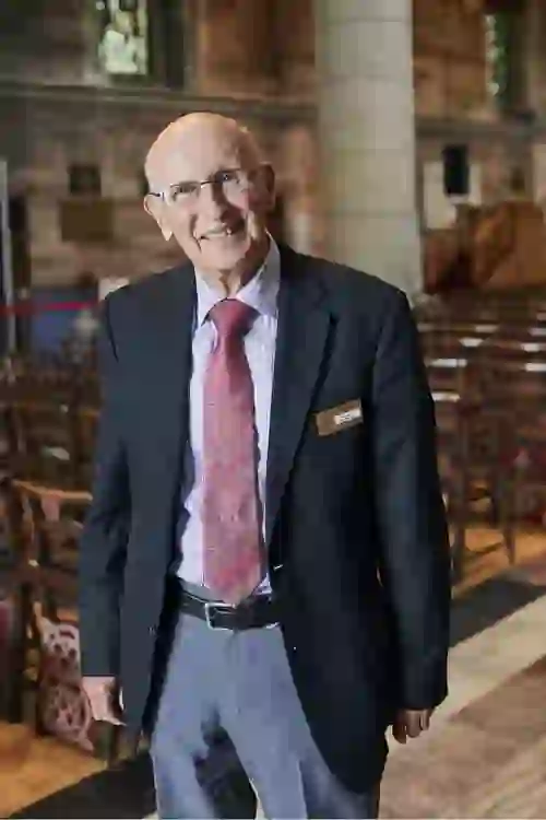 Norman Weatherall, guide at St Anne’s Cathedral Belfast, smiling in the historic church interior.