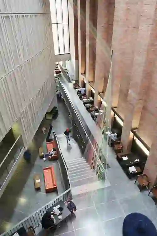 Modern interior of The MAC arts centre in Belfast, with high brick walls and seating areas.