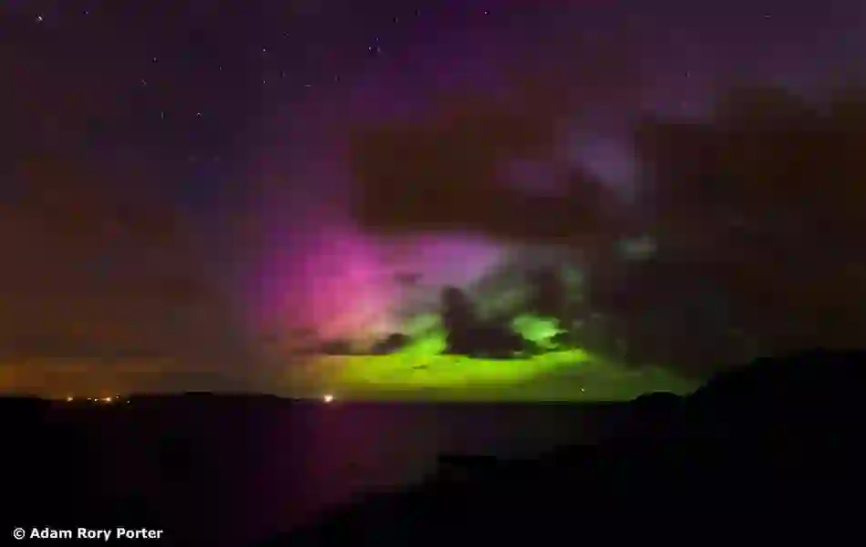 The Northern Lights in green and purple hues illuminate the night sky above Fort Dunree in County Donegal.