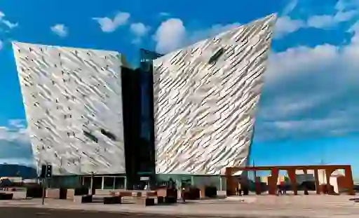 Titanic Belfast museum with striking ship-shaped facade and large ‘TITANIC’ sign outside.