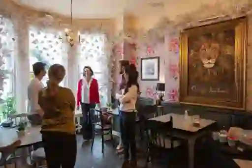 Group gathers inside The Lamppost Café in Belfast, inspired by C.S. Lewis’s Narnia stories, with lion painting on wall.