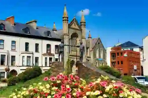 The Hands Across the Divide sculpture in Derry~Londonderry shows two bronze figures reaching towards each other.