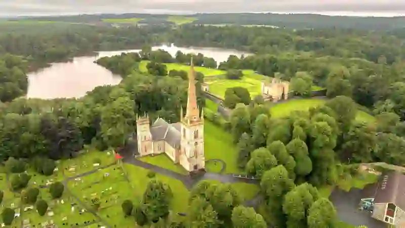 Aerial view of Hillsborough Fort and church surrounded by woodland and lakes in County Down.