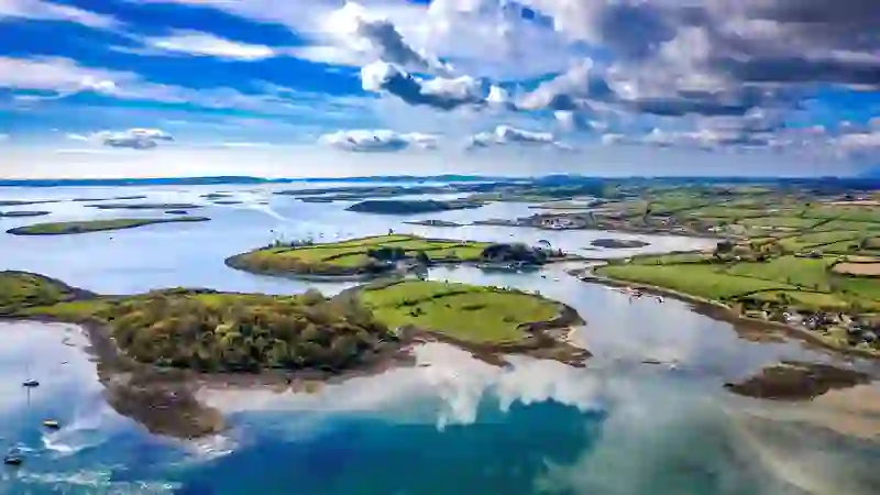 Aerial view of Strangford Lough in County Down with winding waterways, green farmland and dramatic clouds.