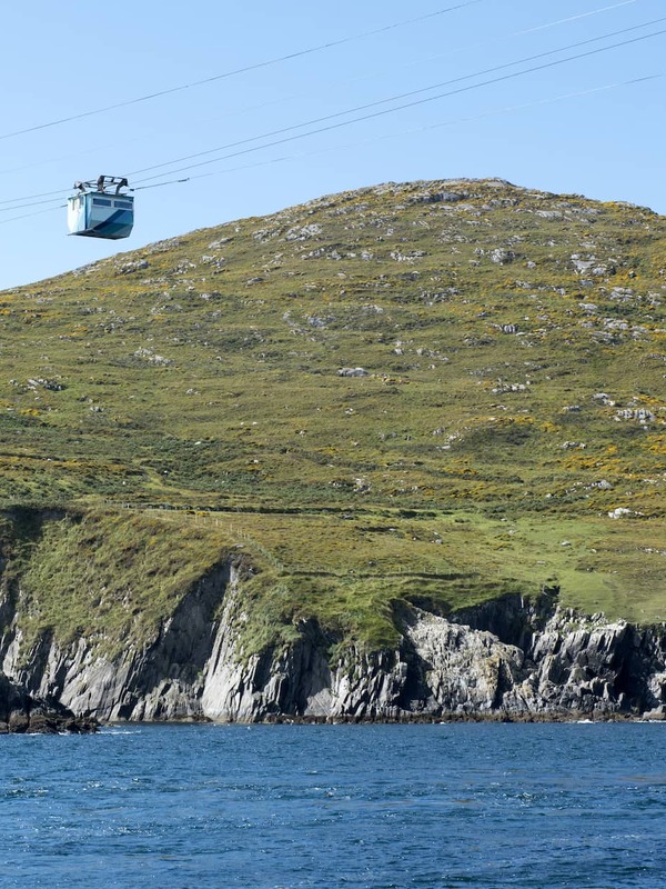Dursey Island cable car over rugged coastline, West Cork, above Atlantic waters on clear day.