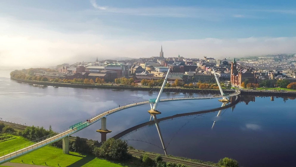 Panoramic aerial of Derry~Londonderry, River Foyle and Peace Bridge in Northern Ireland.
