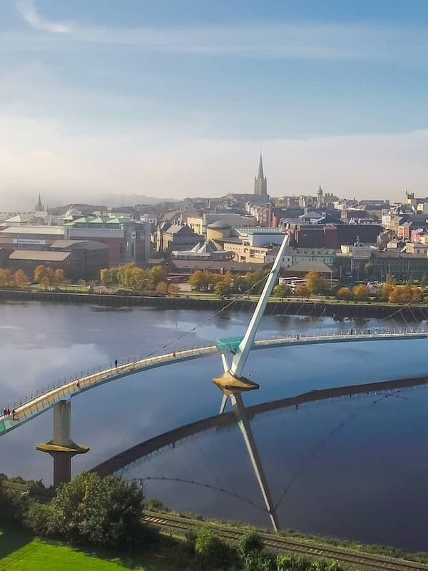 Panoramic aerial of Derry~Londonderry, River Foyle and Peace Bridge in Northern Ireland.