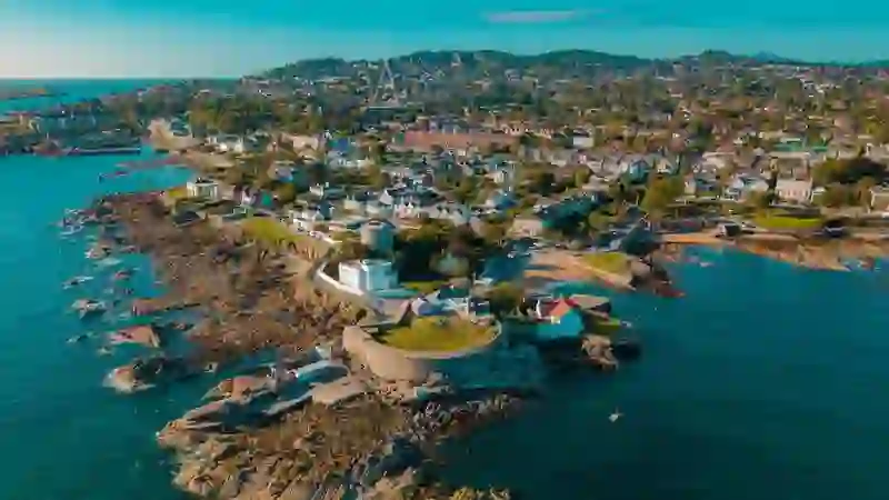 Aerial view of Sandycove’s rocky coastline and Martello tower with Dublin Bay in the background.