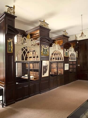 Ornate wooden reading cages with arched lattice doors and old books in Marsh's Library, Dublin.