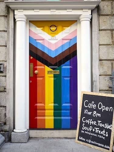 Neon-lit bar in Dublin with Andy Warhol sign and eclectic rainbow decor on Rainbow Mile.