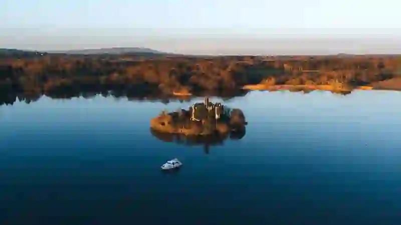 McDermott’s Castle on a small island in Lough Key surrounded by still waters at golden hour, County Roscommon.