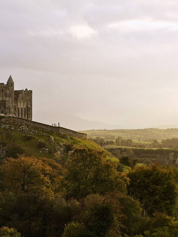 Rock of Cashel rising above the Tipperary countryside under soft evening light.